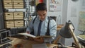 Hispanic detective man reading file in office with map and evidence Royalty Free Stock Photo