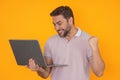 Hispanic excited man working on laptop in studio. Businessman checking email on laptop, writing message in social