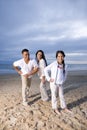 Hispanic family with daughter having fun on beach Royalty Free Stock Photo