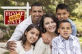 Hispanic Family in Front of Sold Real Estate Sign Royalty Free Stock Photo