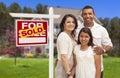 Hispanic Family in Front of Their New Home and Sign Royalty Free Stock Photo