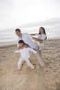 Hispanic family with girl having fun on beach Royalty Free Stock Photo