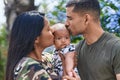 Hispanic family hugging each other and kissing at park Royalty Free Stock Photo