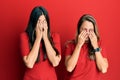 Hispanic family of mother and daughter wearing casual clothes over red background rubbing eyes for fatigue and headache, sleepy Royalty Free Stock Photo