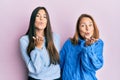 Hispanic family of mother and daughter wearing wool winter sweater looking at the camera blowing a kiss with hand on air being Royalty Free Stock Photo
