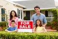 Hispanic family outside home with for sale sign Royalty Free Stock Photo