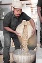 An Hispanic farmer is dropping coffee beans before peeling