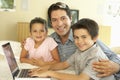 Hispanic Father And Children Using Computer At Home