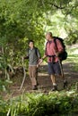 Hispanic father and son hiking on trail in woods Royalty Free Stock Photo