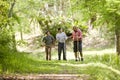 Hispanic father and sons hiking on trail in woods