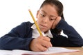 Hispanic female child writing carefully homework with pencil with concentrated face