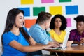 Hispanic female student at computer with group of students Royalty Free Stock Photo