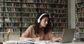 Hispanic female student in headset prepare coursework using books laptop