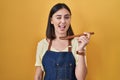 Hispanic girl eating healthy  wooden spoon winking looking at the camera with sexy expression, cheerful and happy face Royalty Free Stock Photo