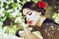 Hispanic girl with fashionable spanish makeup, rose flower in hair. Beautiful Young Woman with Clean Fresh Skin. Royalty Free Stock Photo