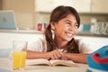 Hispanic Girl Reading Homework At Table Royalty Free Stock Photo