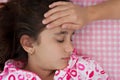 Hispanic girl sick with fever laying in bed Royalty Free Stock Photo