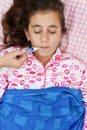 Hispanic girl sick with fever laying in her bed Royalty Free Stock Photo