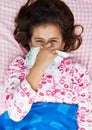 Hispanic girl sick with the flu laying in her bed Royalty Free Stock Photo