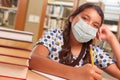 Hispanic Girl Student Wearing Face Mask Studying in Library Royalty Free Stock Photo