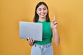 Hispanic girl working using computer laptop surprised with an idea or question pointing finger with happy face, number one Royalty Free Stock Photo