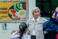 Hispanic Grandmother Buying A Pizza For Her Granddaughter