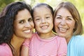 Hispanic Grandmother, Mother And Daughter Relaxing In Park