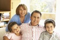 Hispanic Grandparents With Grandchildren Relaxing On Sofa At Hom