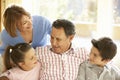 Hispanic Grandparents With Grandchildren Relaxing On Sofa At Home Royalty Free Stock Photo