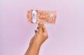 Hispanic hand holding 50 canadian dollars banknote over isolated pink background Royalty Free Stock Photo