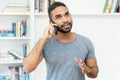 Hispanic hipster man with beard talking at mobile phone Royalty Free Stock Photo