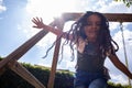 hispanic kid smiling and having fun at the park, child girl at the playground playing on a swing, action low angle shot