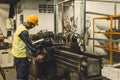 Hispanic Latin Indian male professional tecnician worker working with steel precision milling machine in lathe metal factory