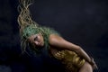 Hispanic Latin woman with green hair and gold costume with handmade flourishes, fantasy image and tale Royalty Free Stock Photo