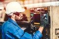 Hispanic latin worker working with machine in heavy industry factory, CNC programming Royalty Free Stock Photo