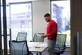 Hispanic male advisor analyzing document at conference table in boardroom at modern workplace