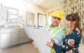 Hispanic Male Contractor Talking with Female Client Over Blueprint Plans In Front of Bathroom Drawing Gradating to Photo Royalty Free Stock Photo