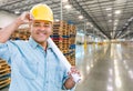 Hispanic Male Contractor Wearing Hard Hat Standing in Empty Industrial Warehouse