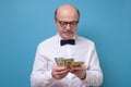 Hispanic male pensioner in glasses counting money dollars Royalty Free Stock Photo