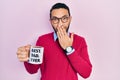 Hispanic man with beard drinking mug of coffee with best dad ever message covering mouth with hand, shocked and afraid for mistake