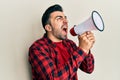 Hispanic man with beard screaming with megaphone