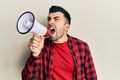 Hispanic man with beard screaming with megaphone