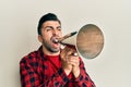 Hispanic man with beard screaming with vintage megaphone Royalty Free Stock Photo