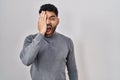 Hispanic man with beard standing over white background yawning tired covering half face, eye and mouth with hand Royalty Free Stock Photo