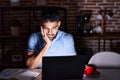 Hispanic man with beard using laptop at night thinking looking tired and bored with depression problems with crossed arms Royalty Free Stock Photo