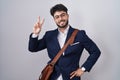 Hispanic man with beard wearing business clothes smiling looking to the camera showing fingers doing victory sign Royalty Free Stock Photo