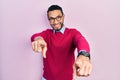 Hispanic man with beard wearing business shirt and glasses pointing to you and the camera with fingers, smiling positive and Royalty Free Stock Photo