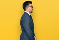 Hispanic man with beard wearing business suit and tie looking to side, relax profile pose with natural face with confident smile Royalty Free Stock Photo