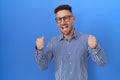 Hispanic man with beard wearing glasses excited for success with arms raised and eyes closed celebrating victory smiling Royalty Free Stock Photo