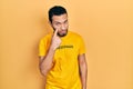 Hispanic man with beard wearing t shirt with happiness word message pointing to the eye watching you gesture, suspicious Royalty Free Stock Photo